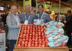 Posing behind a display of Pazazz apples. Ray Griffin with Sabor Farms visits the booth of Honeybear Brands. To the right are Honeybear's Fred Wescott and Don Roper.